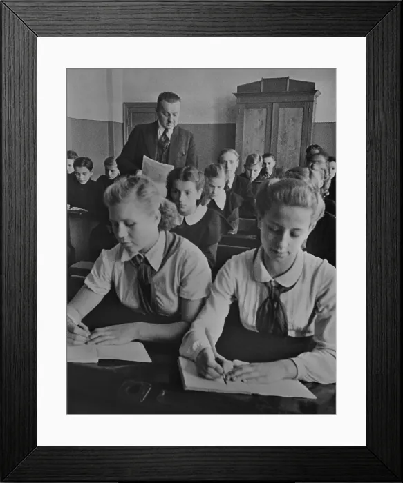 Framed Print : Young Pioneer girls sitting at the front desk in a Latvian USSR sixth grade classroom. They wear the red scarfed uniforms of the Communist youth organization in 1940 Framed Print : Young Pioneer girls sitting at the front desk in a Latvian USSR sixth grade classroom. They wear the red scarfed uniforms of the Communist youth organization in 1940