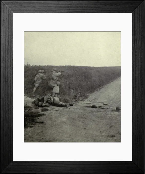 Framed Print : World War 1. French soldier firing at the enemy through the wheat fields southeast of Amiens. The dead German soldier was killed when the first wave of the attack as repulsed