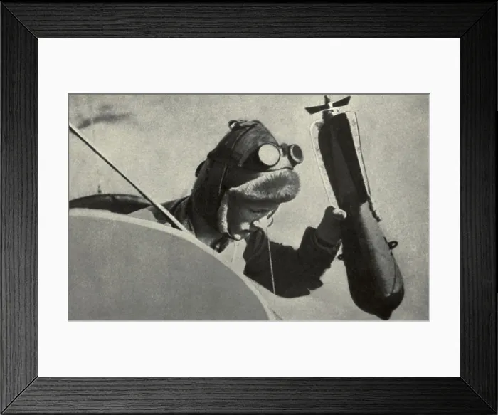 Framed Print : WW1 pilot dropping a handheld bombing from his plane. 1914-1918. (BSLOC_2012_4_71)