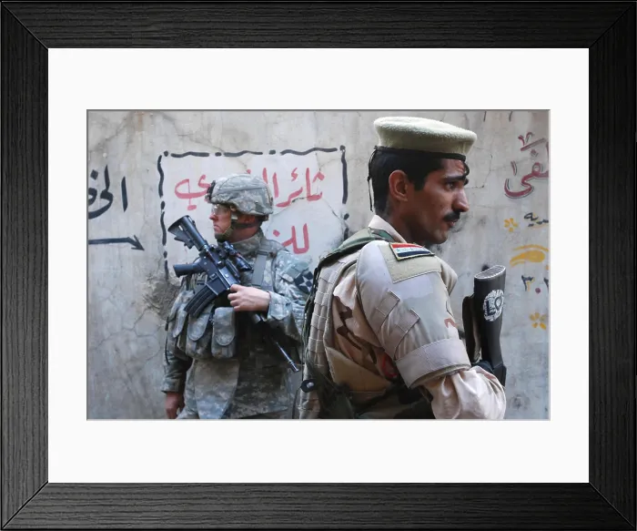 Framed Print : US and Iraqi army soldiers stand guard a market in the Al Doura district of Baghdad Iraq providing security for US Ambassador Ryan Crocker who was touring the city. April 5 2007