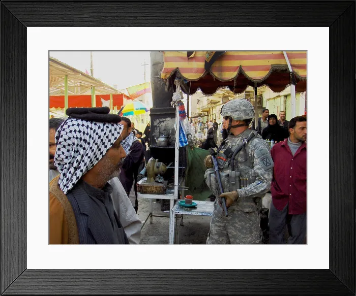 Framed Print : US soldier patrols the streets of Martyrs Market as local nationals shop in Mahmudiyah Iraq a Sunni Iraqi city south of Baghdad which was a center of insurgency during Framed Print : US soldier patrols the streets of Martyrs Market as local nationals shop in Mahmudiyah Iraq a Sunni Iraqi city south of Baghdad which was a center of insurgency during