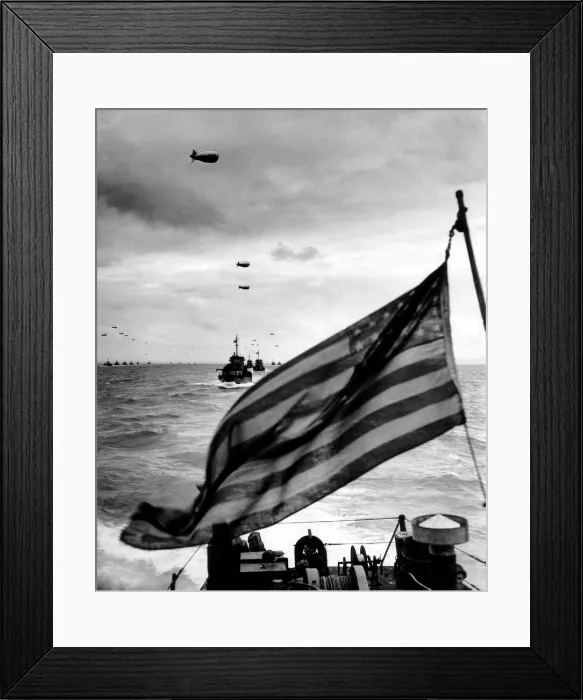 Framed Print : Behind an American flag, a convoy of landing craft head for Utah Beach on June 6, 1944