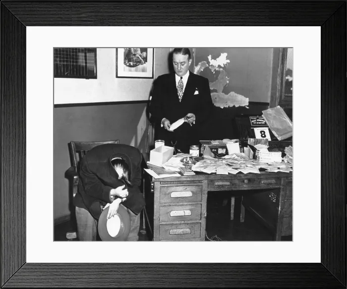 Framed Print : Gangster Joseph Basile, hiding his face with his coat, as photographers take his picture. He was arrested in the seizure of $3 million worth of Narcotics