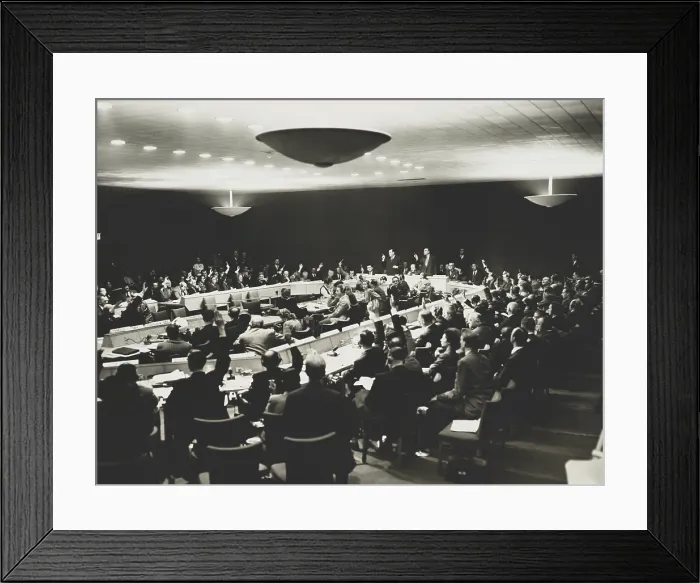 Framed Print : United Nations delegates, some wearing headphones with hands raised to vote. They were voting on a compromise to opposing positions of the U.S. and USSR. Oct. 28, 1947