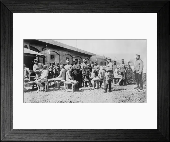 Framed Print : World War 1. Disinfecting German soldiers. Soldiers in French uniforms shave hair from German POWs to prevent lice borne disease. Ca. 1914-18