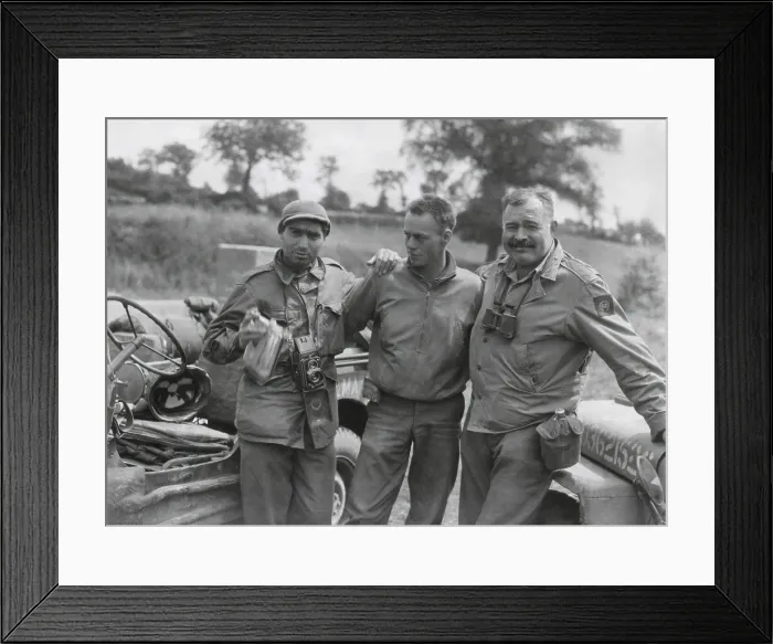 Framed Print : Robert Capa (left) and Ernest Hemingway (right) with their driver U.S. Army driver. They are waiting to follow an American Armored unit into action near Mont Bocard, France