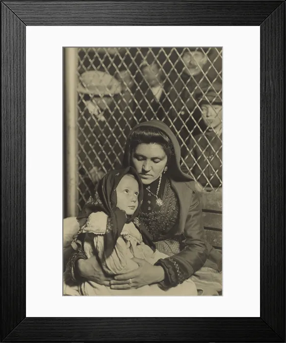 Framed Print : MADONNA AND CHILD, ELLIS ISLAND, 1908, by Lewis Hine. An Italian mother and daughter on a bench separated by a wire partition from a group of men