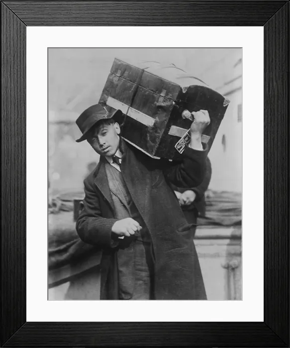 Framed Print : Young male immigrant carrying his trunk on his shoulder at Ellis Island, c. 1905-1915 (BSLOC_2018_1_24)