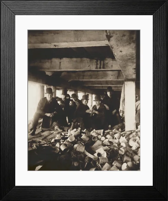 Framed Print : The Short Tail Gang under the Pier at the foot of Jackson Street, 1889, by Jacob Riis. Several men sit under a pier near Corlears Hook eating from cans in New York City