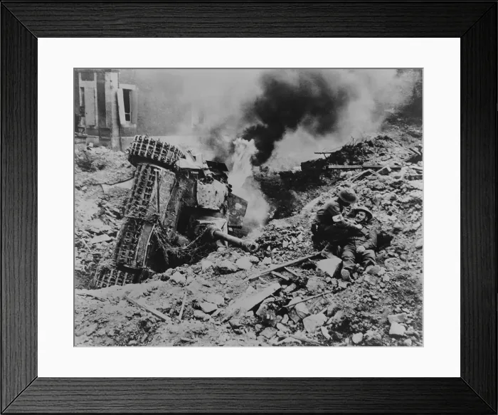 Framed Print : Canadian soldier is attended by a medic near Falaise, France. A burning overturned German tank is the in rubble nearby, during the Battle of the Falaise Pocket
