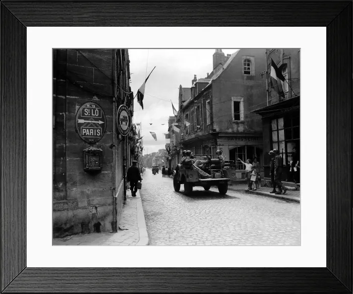 Framed Print : Five U.S. soldier ride through Carentan, France, on the road to Saint-Lo, June 12, 1944. French flags decorate the street of the newly liberated town