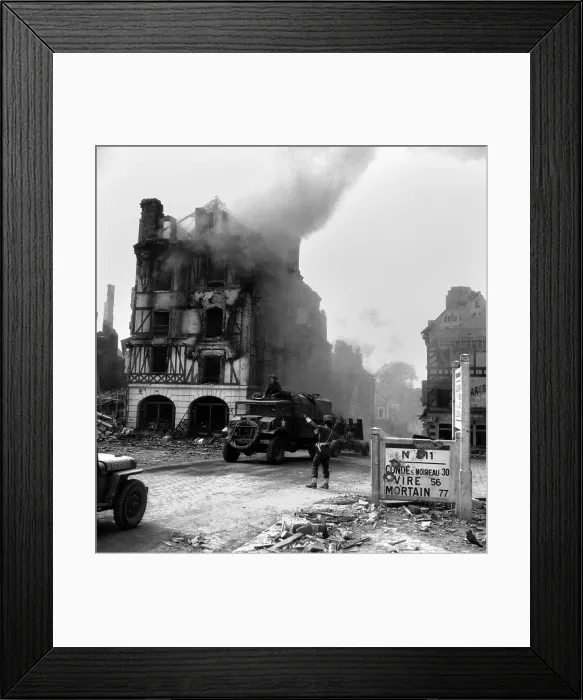 Framed Print : Canadian soldier controls traffic in burning Falaise ruins on August 17, 1944. A truck towing an anti-aircraft gun drives toward the Falaise Pocket. Normandy, France, World War 2
