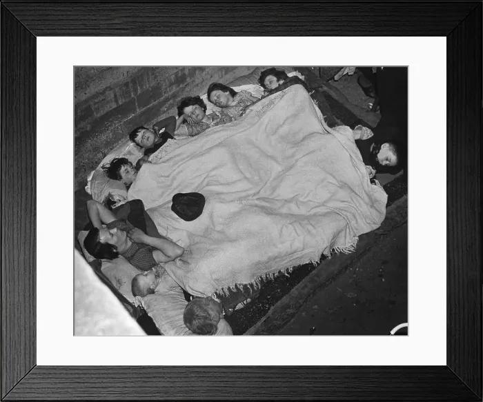 Framed Print : World War 2, Battle of Britain. A woman and eight children share a blanket in a southeast London subway station bomb shell during the Blitz. Ca. 1940-41. (BSLOC_2013_11_97)