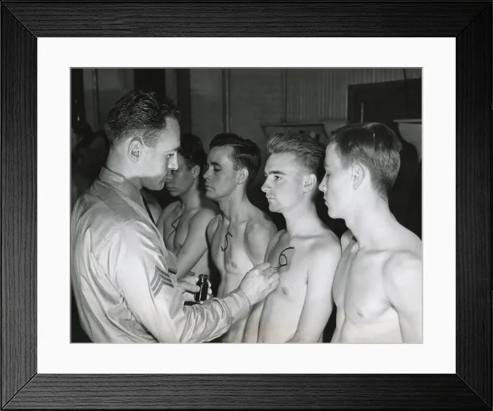 Framed Print : New recruits to the U.S. Army starting their physical exam. The sergeant paints an identification number on the chest of each man to be used throughout the physical examination