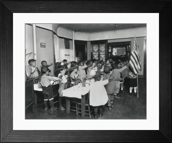 Framed Print : African American children salute the flag in classroom, c. 1910. The primary school children make the old straight arm salute