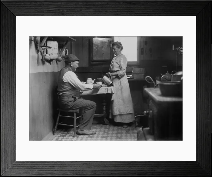 Framed Print : Woman pouring a cup of coffee for a man at the table in Broad Channel, Queens, NYC