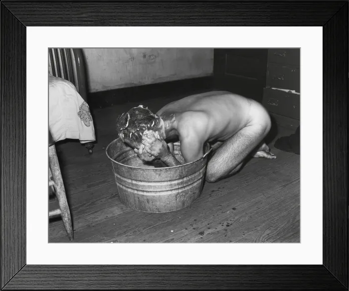 Framed Print : Coal miner Milong Bond taking a bath from a metal wash basin. His home probably lacks an indoor bathroom. Wyoming County, West Virginia. August 23, 1946. By Russell Lee