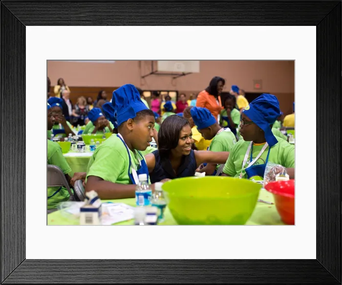 Framed Print : First Lady Michelle Obama talks with kids making trail mix at the McAlpine Park, Alabama. July 18, 2012 (BSLOC_2015_13_176)