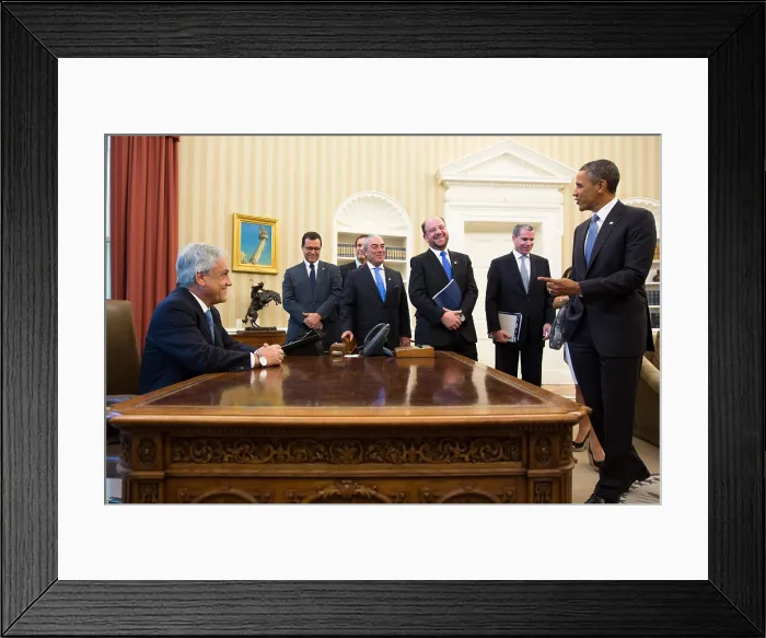 Framed Print : President Sebastian Pinera of Chile sits at the Obama's Resolute Desk in the Oval Office. The Chilean delegates share the good humor. June 4, 2013. (BSLOC_2015_3_151)