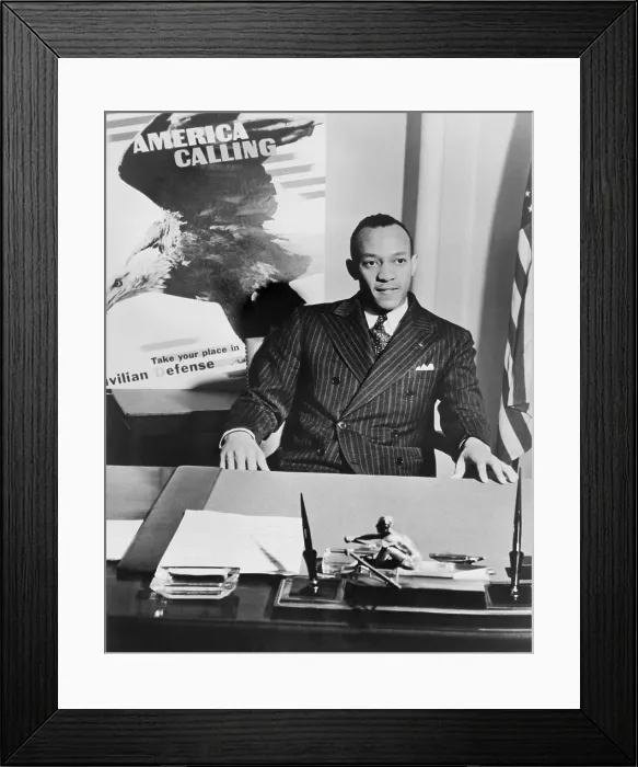 Framed Print : Jesse Owens, half-length portrait, seated at desk, as National Coordinator of Racial Activities in 1942