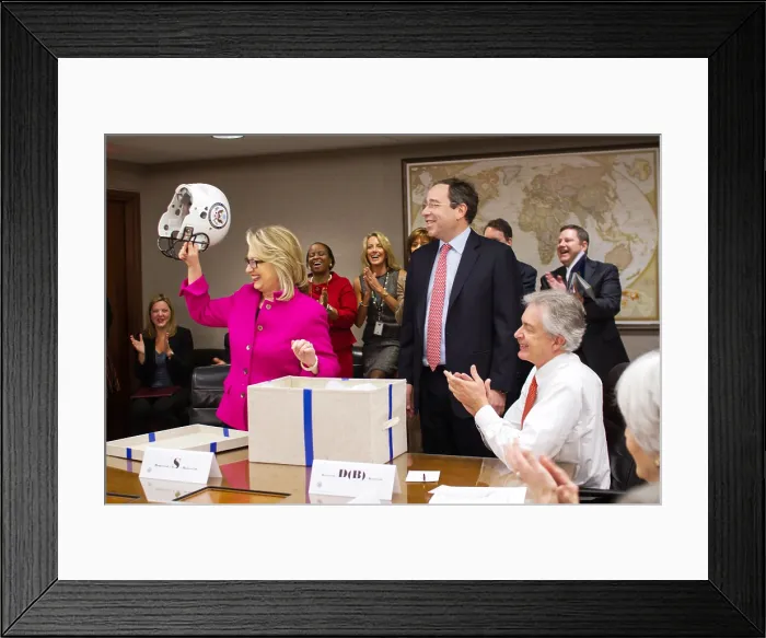 Framed Print : U.S. Sec. of State Hillary Clinton is presented with a football helmet at the State Department. Jan. 7, 2013 was her first day back to work after her head injury of Dec. 11, 2012