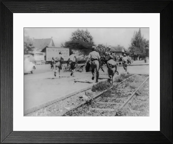 Framed Print : War for Indonesian independence began in 1945. Soldiers running down street with revolutionary billboards in the background. - (BSLOC_2014_15_175)