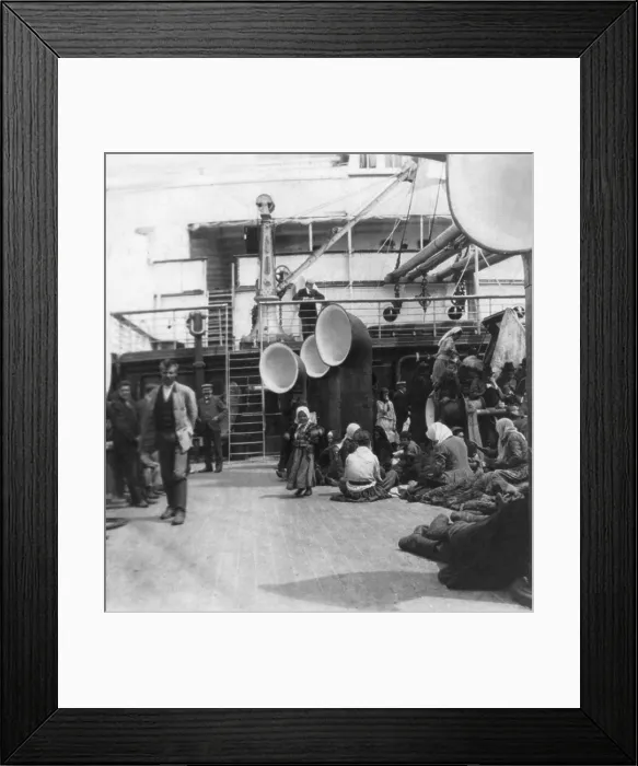 Framed Print : Steerage passengers taking life easy on an ocean liner. Immigrants relax and stroll on the open deck amidst ventilation funnels. Ca. 1905