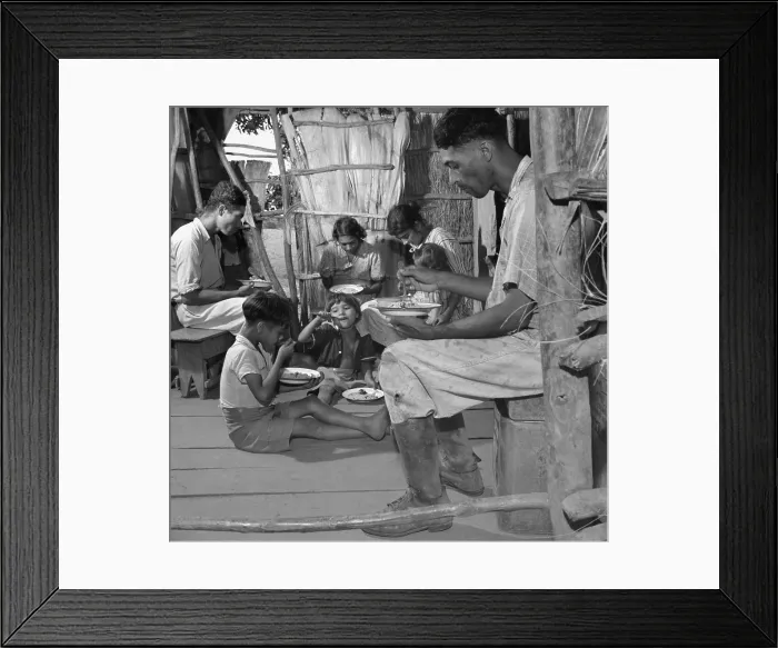 Framed Print : Puerto Rican family eating their main meal: rice, beans and a few pieces of codfish, Jan. 1938. The open tropical home interior is unfinished but clean. Photo by Edwin Rosskam