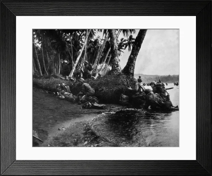 Framed Print : American invasion of Rendova Island, Solomon Islands, June 30, 1943. Attacking at the day break in a heavy rainstorm, the first Americans ashore huddle behind tree trunks