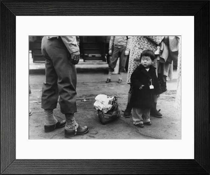 Framed Print : Small child looks apprehensively at the U.S. soldier supervising the transport of Los Angeles Japanese-Americans to Owens Valley Relocation Center during World War II. April 1942 Framed Print : Small child looks apprehensively at the U.S. soldier supervising the transport of Los Angeles Japanese-Americans to Owens Valley Relocation Center during World War II. April 1942