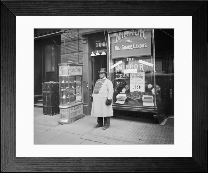 Framed Print : African American promoting Dr. Ranklins Dental Parlor with on his doubled breasted coat. The door of 366 Fifth Avenue in open and a glass case displays set of false teeth