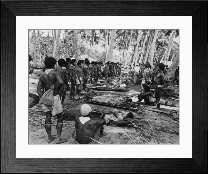 Framed Print : New Guinean native stretcher bearers pause in their transport of American wounded