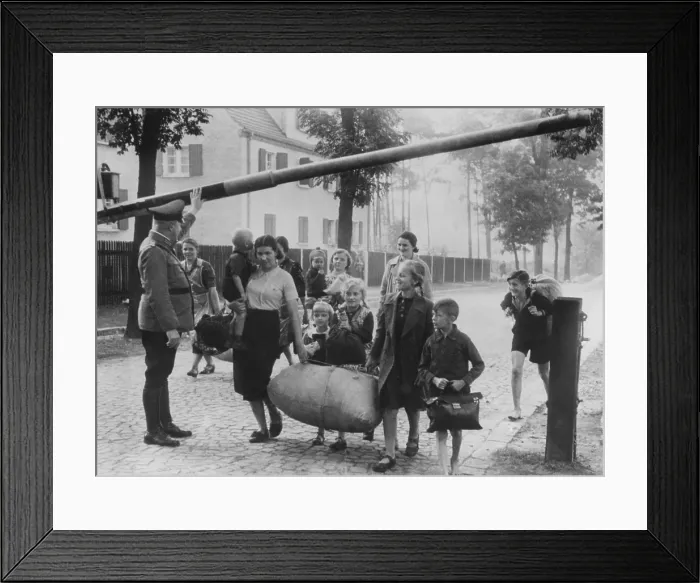 Framed Print : German nationals leave Polish territory, supposedly fleeing persecution at hands of the Poles. Women and children pass through the German border fence, not far from Danzig