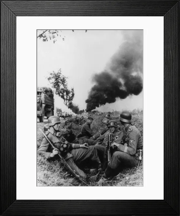 Framed Print : German soldiers resting in a ditch on way to Pabjanice, during the invasion in Poland. In distance is a cloud of smoke from burning buildings. World War 2. Sept. 1939