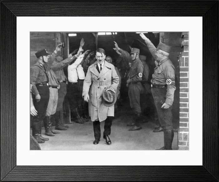 Framed Print : Adolf Hitler, emerging from a Nazi party meeting after a speech, 1930s. He is saluted by uniformed Storm Troopers