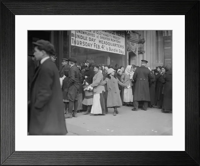 Framed Print : Adults and children gather for clothing distribution in NYC, Feb. 1915. Sign reads, Bundle of Clothing for the Needy Unemployed of Greater New York. Thursday Feb