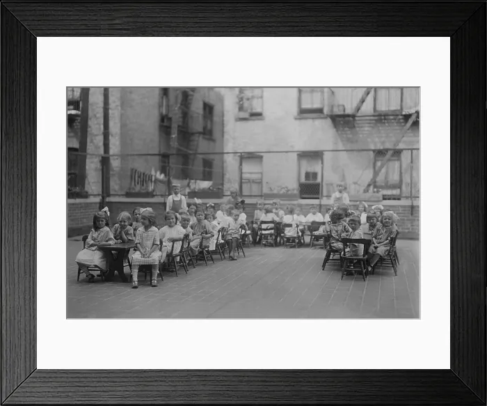 Framed Print : Kindergarten children sit in chairs at long tables on the roof of the Lenox Hill Settlement House, c. 1915-20. (BSLOC_2018_1_155) Framed Print : Kindergarten children sit in chairs at long tables on the roof of the Lenox Hill Settlement House, c. 1915-20. (BSLOC_2018_1_155)