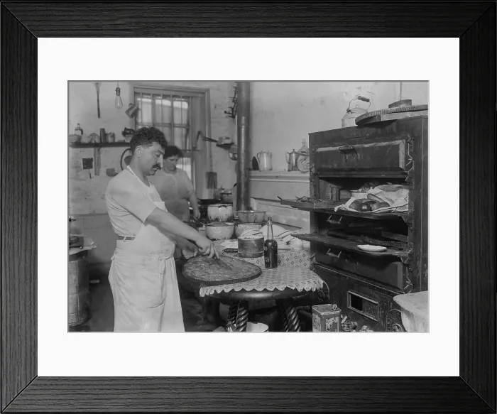 Framed Print : Lebanese-Syrian immigrant pastry cook cutting into a phyllo dough sweet made in the rustic kitchen of in a New York City ethnic restaurant. Ca. 1910