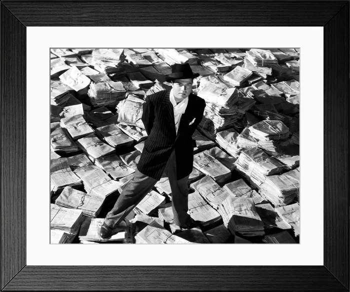Framed Print : CITIZEN KANE, Orson Welles, 1941, astride stacks of newspaper