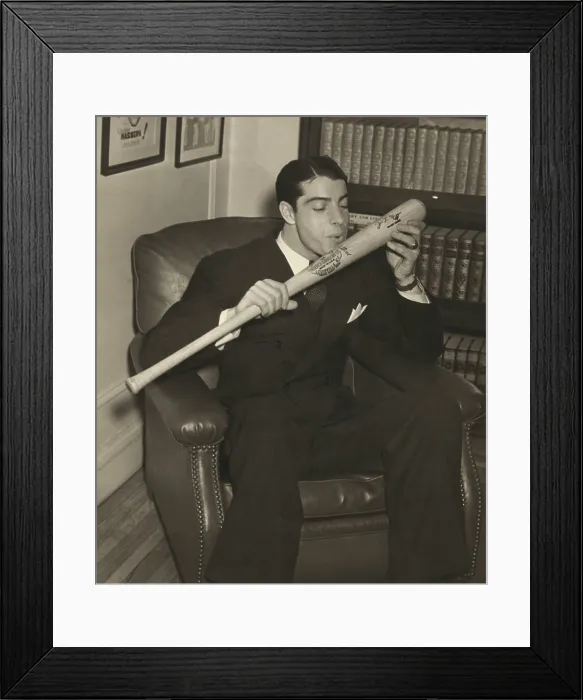 Framed Print : Joe DiMaggio, of the New York Yankees, kisses his signature baseball bat, Dec. 1941. DiMaggios 1941 record for a 56-game hitting streak still stands (BSLOC_2018_3_191)