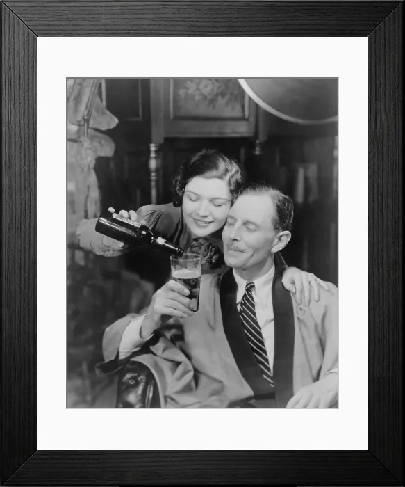 Framed Print : Young woman pouring beer into a man's glass, 1933