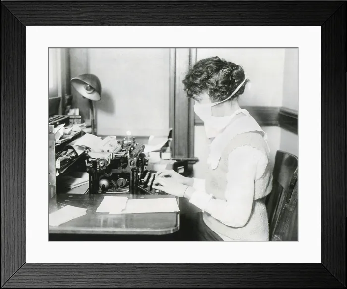 Framed Print : Spanish Flu Epidemic 1918-1919 in America. Wearing a gauze surgical mask while working, this typist protects herself against influenza. New York City, Oct