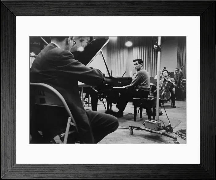 Framed Print : Leonard Bernstein, playing piano, amidst other musicians during a rehearsal in 1958. (BSLOC_2015_14_164)