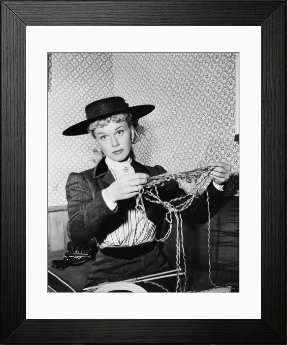 Framed Print : THE WINNING TEAM, Doris Day knitting a sweater for co-star Ronald Reagan on set, 1952