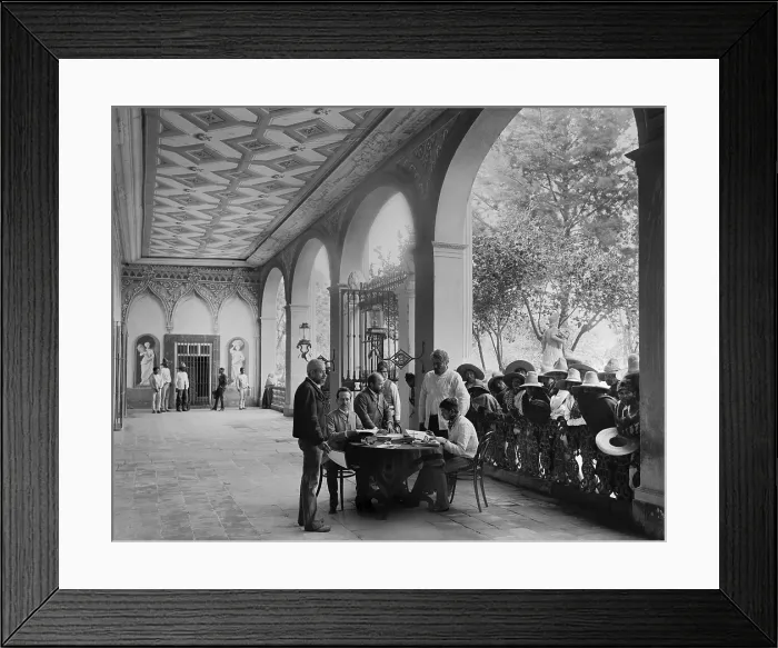 Framed Print : European-Mexican administrator sits in a Hacienda porch, San Luis Potosi, Mexico, c. 1890. Landless mestizo peons wait their turn for an audience with the plantation manager