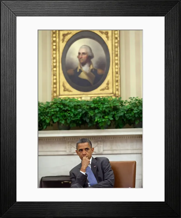 Framed Print : President Barack Obama listens to advisors in the Oval Office. Aug. 18, 2011. Above him is the Porthole Portrait of George Washington (1795) by Rembrandt Peale. (BSLOC_2015_3_7)