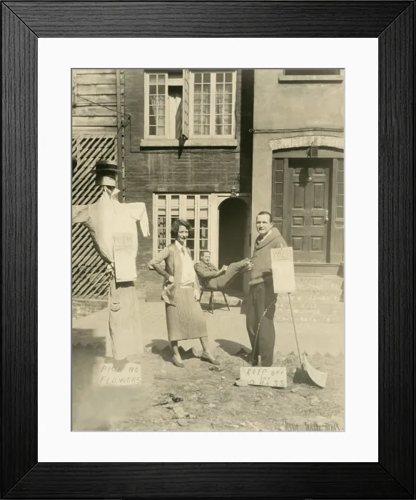 Framed Print : Edna St. Vincent Millay and her husband, Eugen Jan Boissevain, at Greenwich Village house, c. 1925. They stand with a mannequin, signs, and an unidentified man sits in background