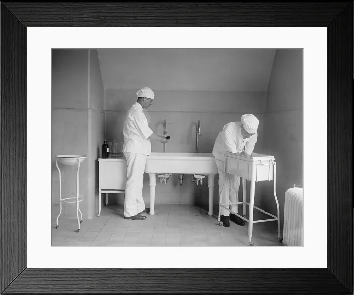 Framed Print : Surgeon and anesthesiologist carefully wash their hands and lower arms in specialized sinks. Before antibiotics post-operative infection was a serious concern