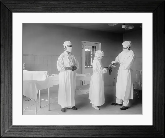 Framed Print : Surgical nurse assists surgeons into rubber gloves before an operation. 1922 in a hospital in Washington, D.C. (BSLOC_2016_10_32) Framed Print : Surgical nurse assists surgeons into rubber gloves before an operation. 1922 in a hospital in Washington, D.C. (BSLOC_2016_10_32)