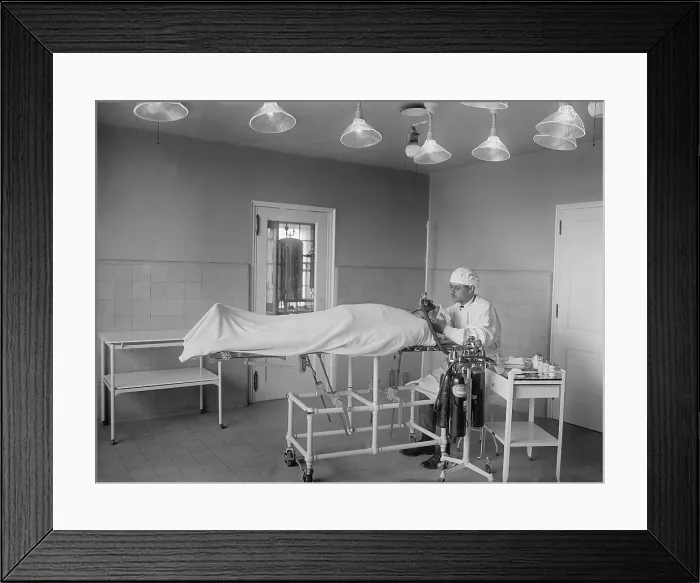 Framed Print : Anesthesiologist administers ether and nitrous oxide to patient before surgery in operating room. 1922 in a hospital in Washington, D.C. (BSLOC_2016_10_33) Framed Print : Anesthesiologist administers ether and nitrous oxide to patient before surgery in operating room. 1922 in a hospital in Washington, D.C. (BSLOC_2016_10_33)